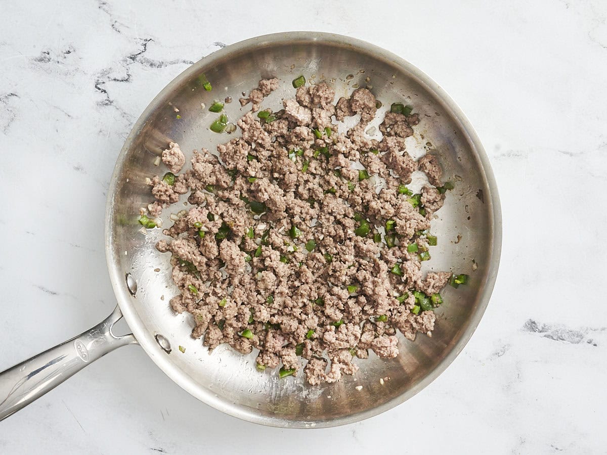 Ground beef browning in a skillet.