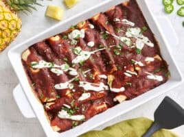 Overhead view of beef enchiladas in a baking dish.