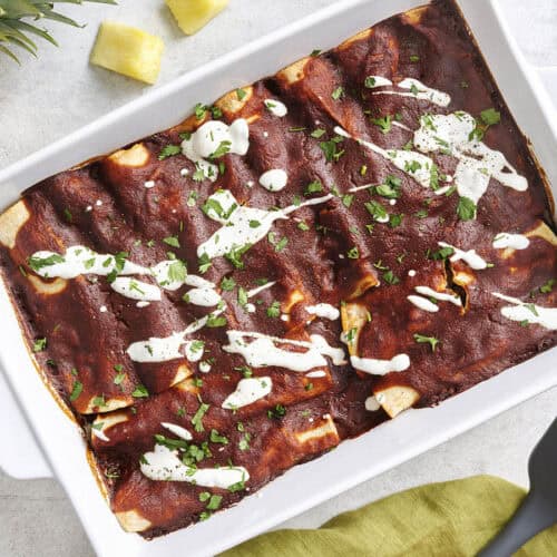 Overhead view of beef enchiladas in a baking dish.