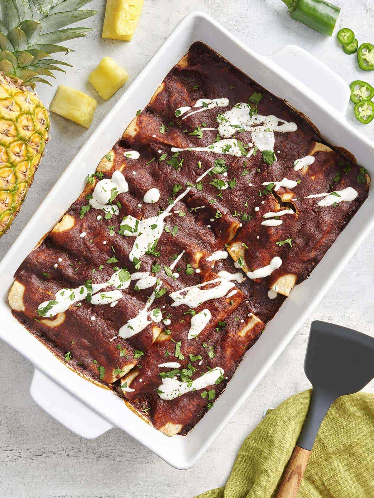 Overhead view of beef enchiladas in a baking dish.