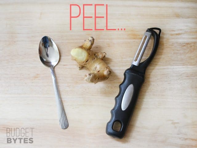 Piece of ginger with peeler and spoon