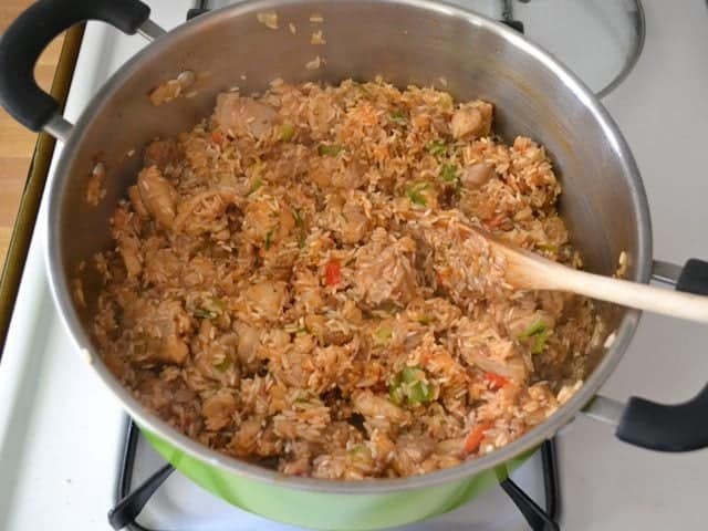 Rice and Tomato Paste added to other ingredients in pot