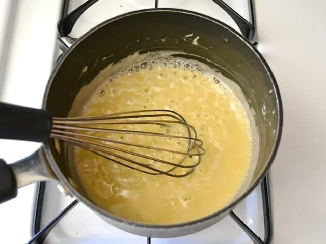 Sauce ingredients in pan with whisk