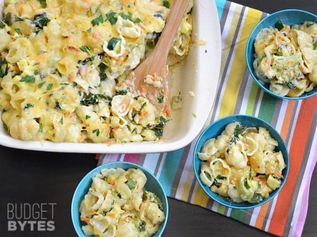Casserole dish of Vegetable Alfredo Pasta Bake with three small bowls served up