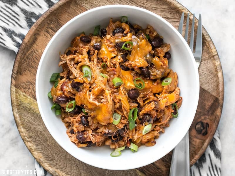 If you're looking for a quick and easy dinner, this Southwest Chicken Skillet is it! Precooked chicken makes this dinner possible in about 30 minutes. BudgetBytes.com Top view of a bowl of southwest chicken skillet with a fork on the side