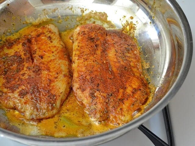 Cooked Tilapia in skillet on stove top