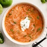 Overhead view of homemade sopa de fideo in a bowl topped with sour cream.