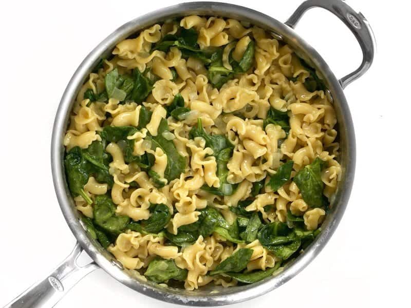 Spinach added to skillet with cooked pasta