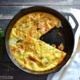Slices of zucchini and corn frittata on a cast iron pan.