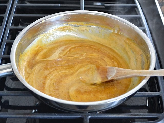 Cream added into pumpkin sauce mixture in pan