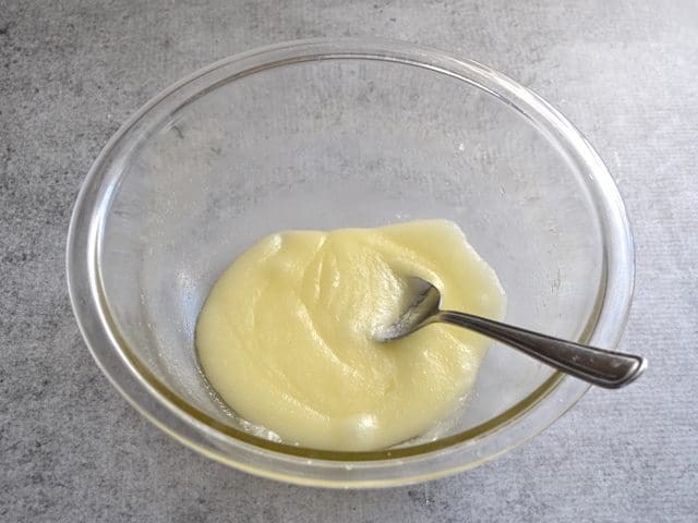 Sugar added to melted butter in mixing bowl with spoon