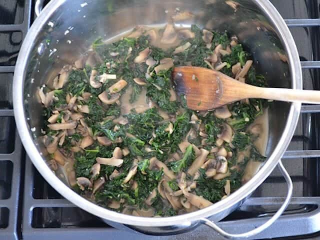 Kale added to mushrooms in pot