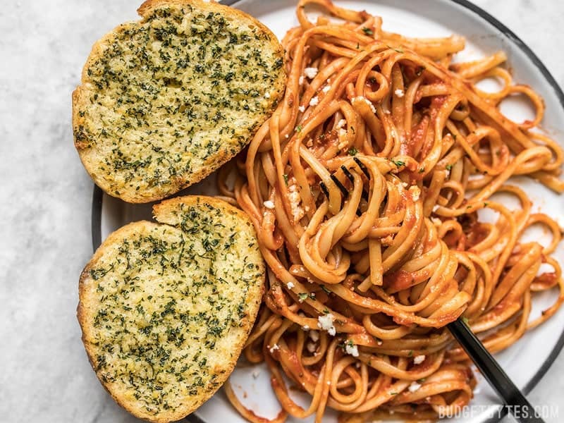 Make your own homemade freezer garlic bread slices, ready to bake on demand. Bake two or ten frozen slices at a time, ready in minutes! Budgetbytes.com Two slices of freezer garlic bread on a plate with pasta