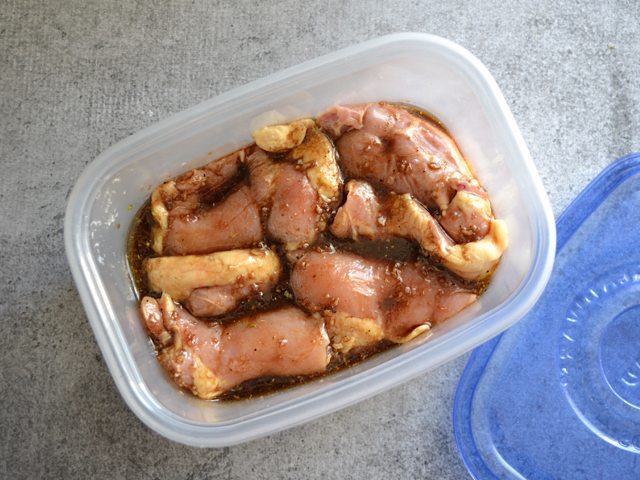 Chicken and marinade in a Tupperware container to marinate