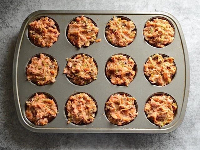 Muffin tin filled with meat and veggie meatloaf mixture