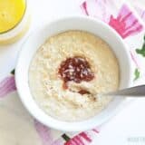A bowl of toasted coconut oat bran with fruit and a glass of orange juice.