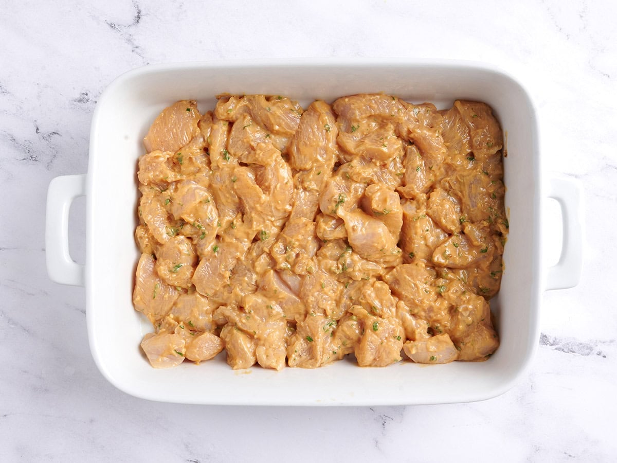 Marinated chicken in a baking dish.