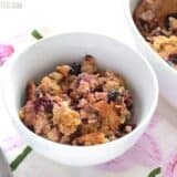 A bowl of apple cherry baked oatmeal with toppings.