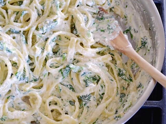 This quick and luxurious Spinach Ricotta Pasta boasts a creamy and garlicky spinach sauce made easy with ricotta cheese. Perfect for weeknight dinners! Budetbytes.com Finished Spinach Ricotta Pasta close up in the skillet