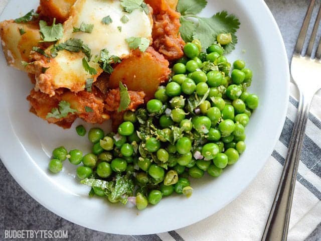 Plate with main dish and Minty Pea Salad as side dish, fork on the side