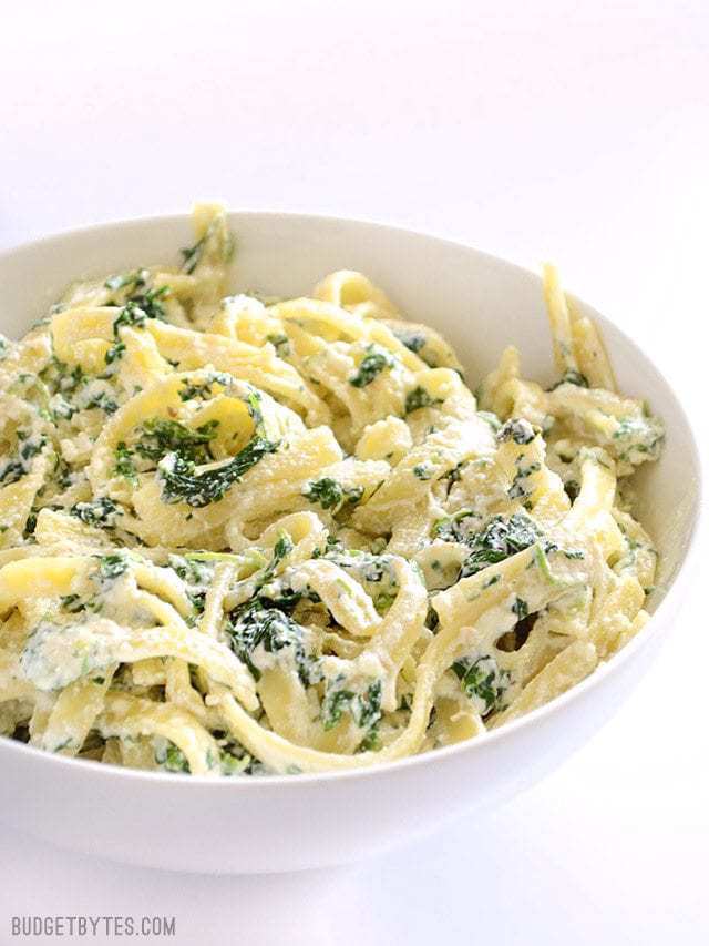 This quick and luxurious Spinach Ricotta Pasta boasts a creamy and garlicky spinach sauce made easy with ricotta cheese. BudgetBytes.com V2 Close up side view of a serving bowl full of spinach ricotta pasta