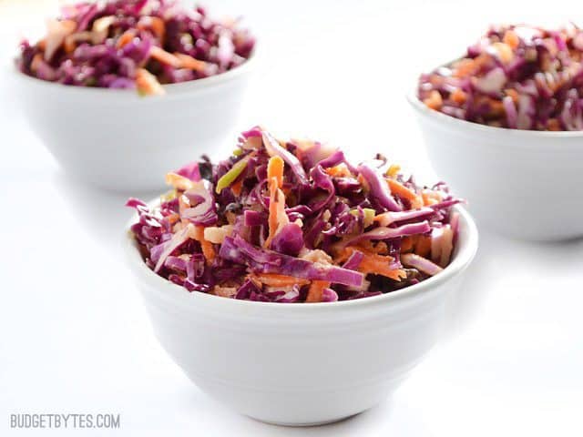 This sweet-tart Apple Cabbage Slaw combines Granny Smith apples, raisins, and a Greek yogurt dressing for a light and fresh twist on classic slaw. Budgetbytes.com Three small bowls of Apple Cabbage Slaw viewed from the side