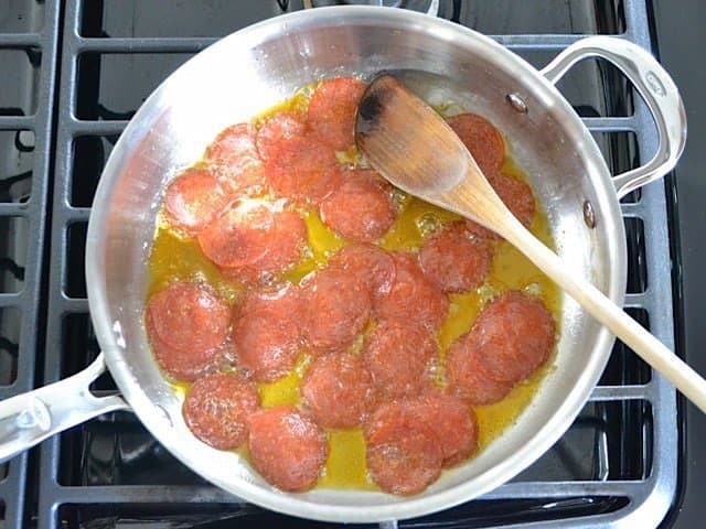 Frying pepperoni in skillet with olive oil