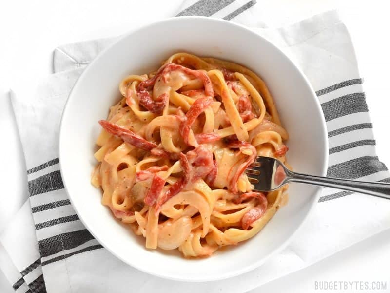 This smoky, sweet, and creamy One Pot Roasted Red Pepper Pasta cooks in one single pot and can be on the table in about 30 minutes. BudgetBytes.com A bowl of One Pot Roasted Red Pepper Pasta with some wound around a fork