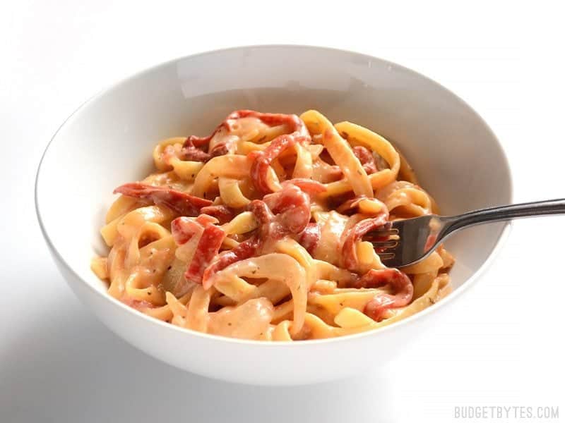 This smoky, sweet, and creamy One Pot Roasted Red Pepper Pasta cooks in one single pot and can be on the table in about 30 minutes. BudgetBytes.com Side view of a bowl of One Pot Roasted Red Pepper Pasta