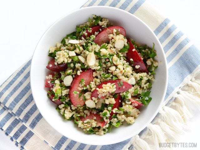 This fresh plum salad with lemon ginger dressing is a great way to use up leftover cooked grains and the summer's fresh produce. Budgetbytes.com Overhead view of a bowl full of Plum Salad with Lemon Ginger Dressing