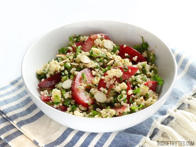 This fresh plum salad with lemon ginger dressing is a great way to use up leftover cooked grains and the summer's fresh produce. Budgetbytes.com Side view of a bowl of Plum Salad with Lemon Ginger Dressing