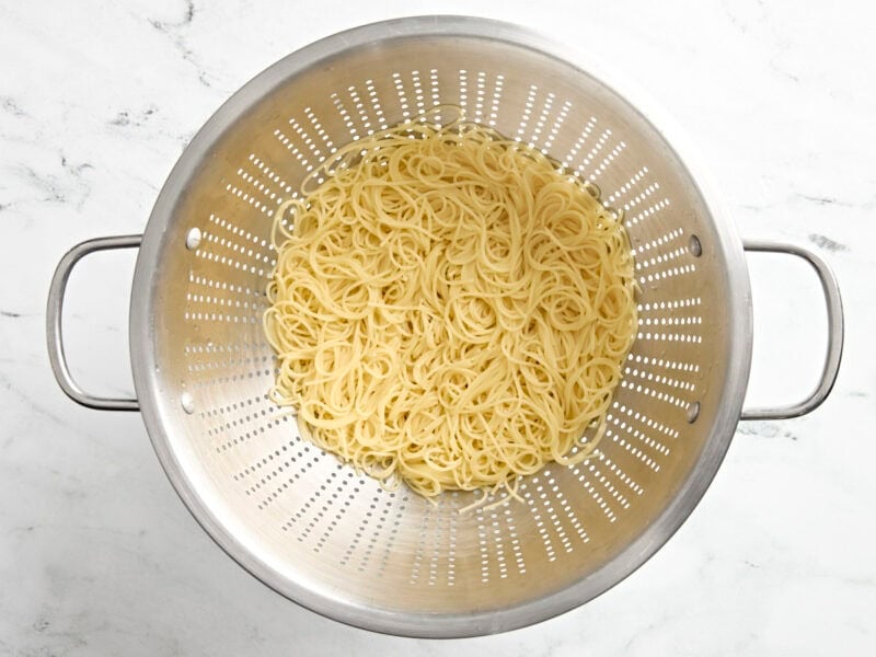 Cooked noodles in a colander.
