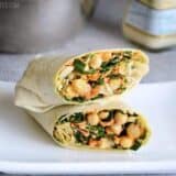 A chicken kale Caesar wrap presented on a plate.