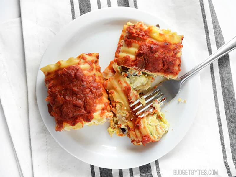 With a rainbow of vegetables and a trio of cheeses, these Garden Vegetable Lasagna Roll Ups are a flavorful and filling meal. Freezer friendly, too! Budetbytes.com Two vegetable lasagna roll ups on a plate, one cut with a fork