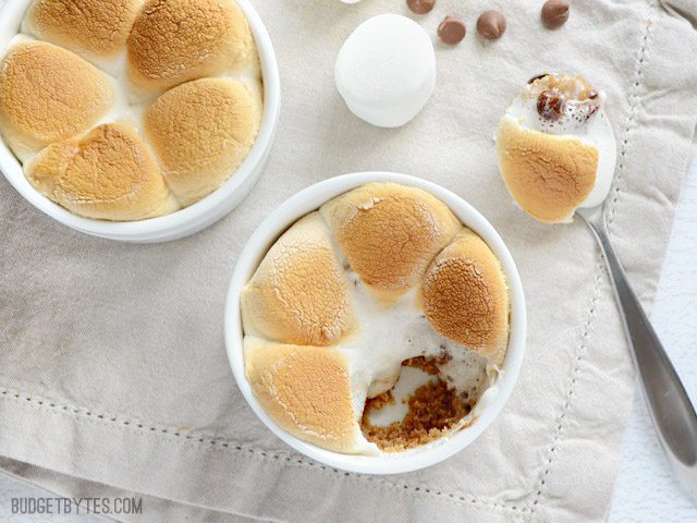 Get your favorite gooey s'mores flavors in a layered, oven baked S'mores Pot. Graham cracker crust, peanut butter, chocolate chips, and toasted marshmallows. Budetbytes.com Two Peanut Butter S'mores Pots, one with a spoonful removed