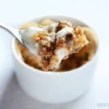 A spoon resting in a peanut butter s'mores dessert pot.