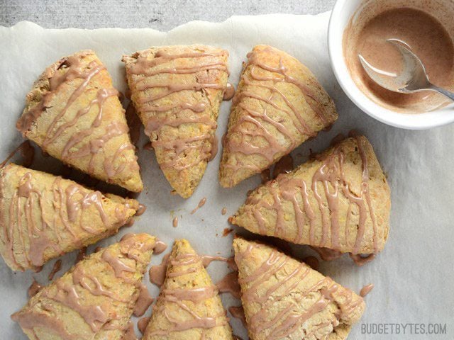 Inspired by a fresh baked apple pie, these Apple Pie Scones are flavored with cinnamon, ginger, and bits of shredded fresh apple. Budetbytes.com Glaze drizzled over baked apple pie scones