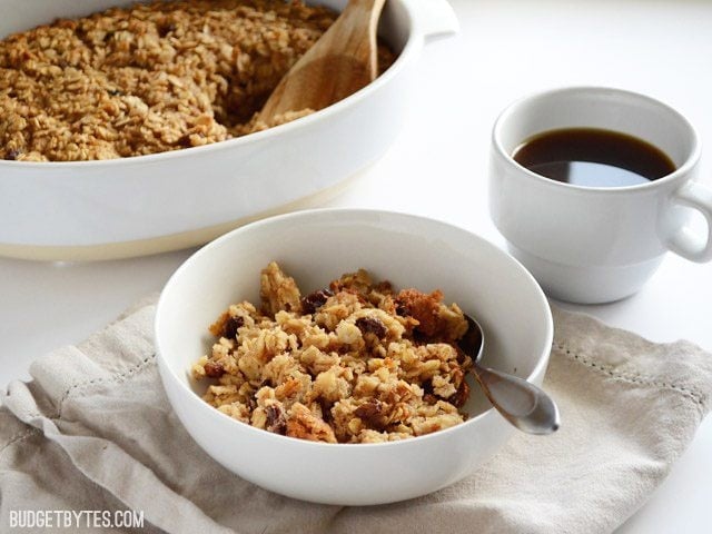This freezable Oatmeal Cookie Baked Oatmeal tastes like an oatmeal cookie's older, more healthful sibling. Perfect for breakfast meal prep. Budetbytes.com Front view of a bowl of "Oatmeal Cookie" Baked Oatmeal casserole dish in the back
