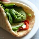 A wrap filled with roasted red pepper hummus and greens.