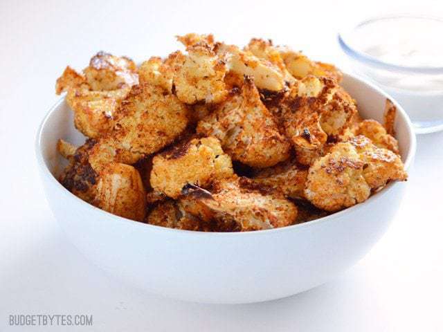 Smoky Parmesan Roasted Cauliflower is an easy, smoky, and savory side dish or snack for dipping in your favorite sauces. Step by step photos. Budetbytes.com Side view of a bowl of Smoky Parmesan Roasted Cauliflower