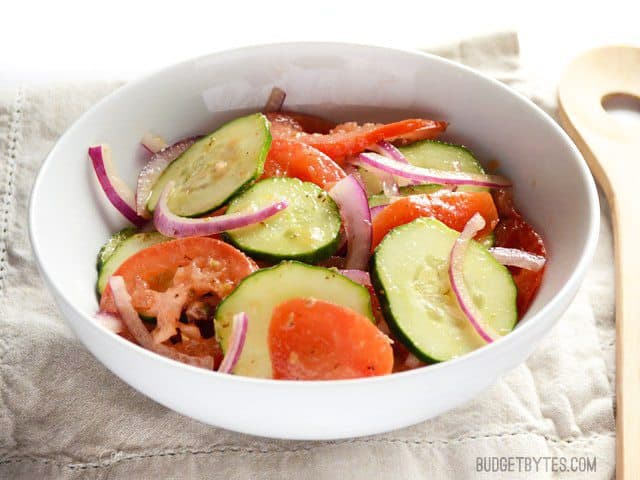 Three simple vegetables and a quick homemade vinaigrette make this Simple Tomato Cucumber Salad a sumertime staple! Fresh, easy, and delicious! Budgetbytes.com Front view of a bowl of Simple Cucumber Tomato Salad