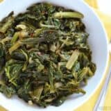 A close-up of cooked vegetarian mustard greens in a bowl.