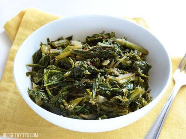 Delicious and smoky mustard greens can be made meat free! Simmering in smoked paprika and vegetable broth gives these greens a deep, rich flavor. Budetbytes.com Side view of a bowl of Vegetarian Mustard Greens
