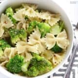 A close-up of bowtie pasta mixed with broccoli and sauce.
