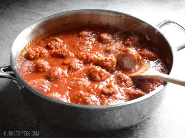 These quick and easy skillet meatballs are made in one skillet with marinara and pack a huge flavor punch. They're my new weeknight dinner favorite! Budetbytes.com Side view of the meatballs and marinara in a deep skillet