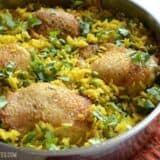 A close-up of yellow rice chicken skillet in a pan.