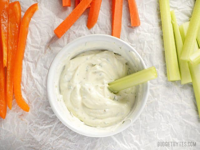 This super quick and flavorful vegetable dip makes snacking on fresh produce easy and delicious. Use as a vegetable or chip dip, or sandwich spread. Budetbytes.com Overhead view of a celery stick dipped into Dilly Vegetable Dip