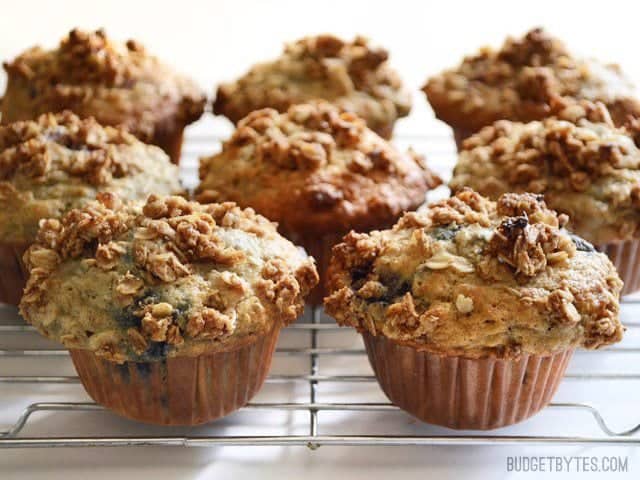 These big, moist, and fluffy Triple Berry Oatmeal Muffins are a real treat for breakfast and boast the goodness of rolled oats. Freezer friendly! Budetbytes.com Several Triple Berry Oatmeal Muffins on a wire cooling rack