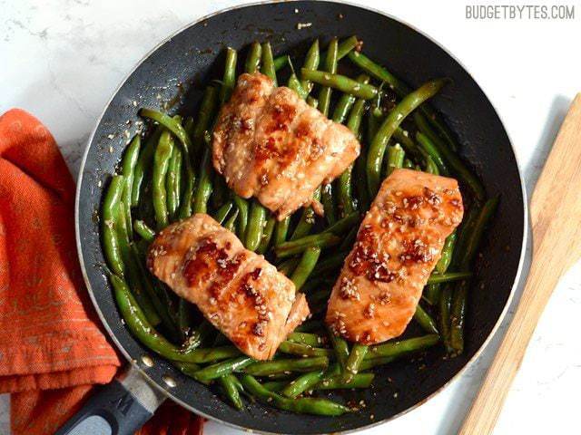 This incredible fast and easy Sesame Glazed Salmon dinner is faster than take-out and fancy enough to impress your friends and family. Budetbytes.com Sesame Glazed Salmon and Green Beans in the skillet, orange napkin on the side