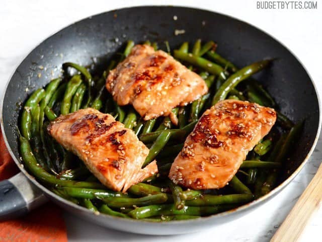 This incredible fast and easy Sesame Glazed Salmon dinner is faster than take-out and fancy enough to impress your friends and family. Budetbytes.com Side view of a pan with Sesame Glazed Salmon and Green Beans inside